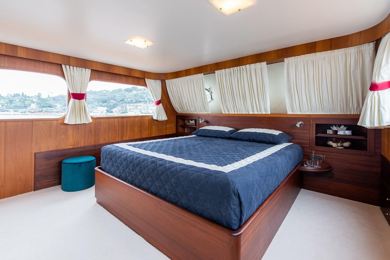 a bedroom with a bed and a window aboard SANS SOUCI Yacht for Sale