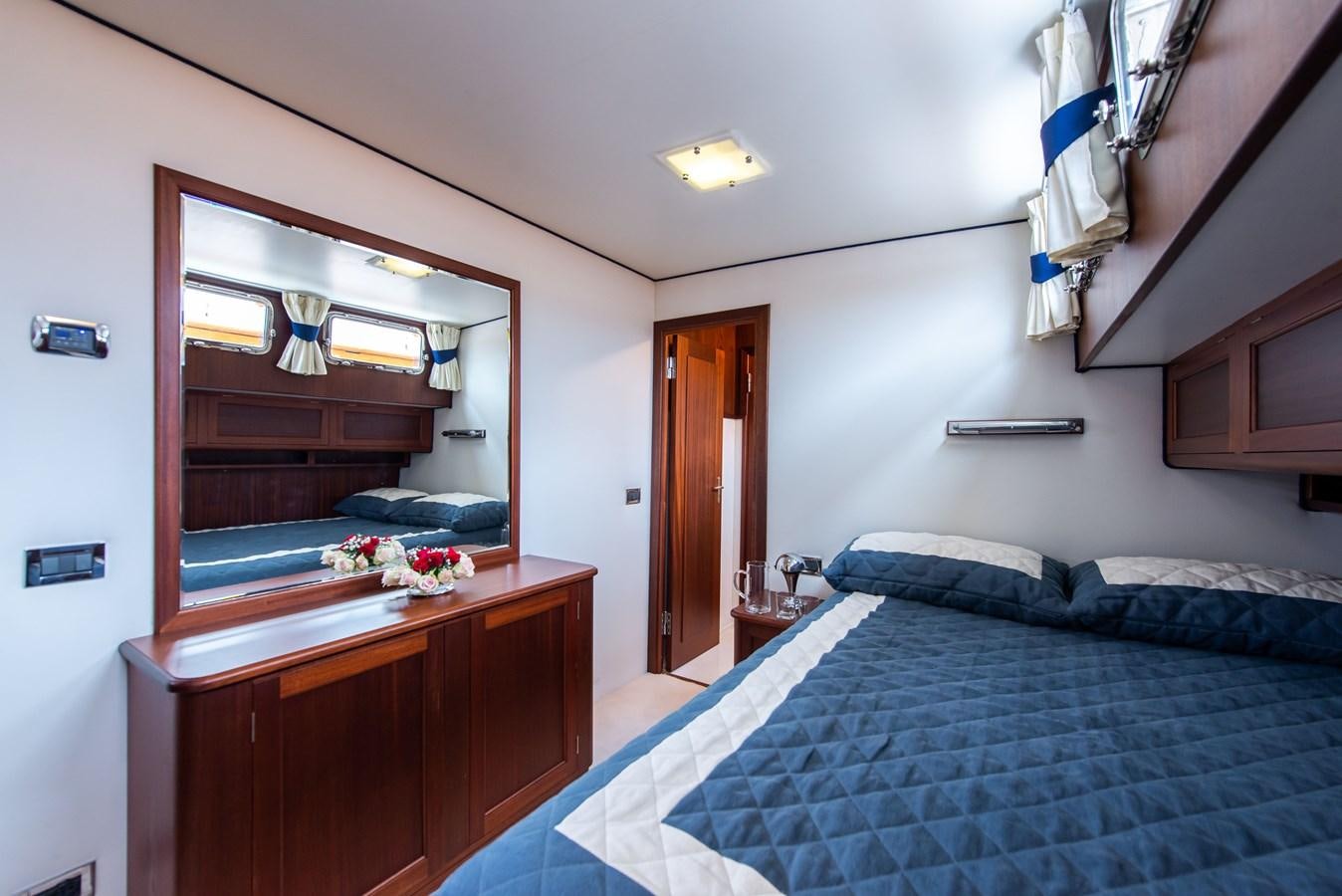 a bedroom with a bed and a mirror aboard SANS SOUCI Yacht for Sale