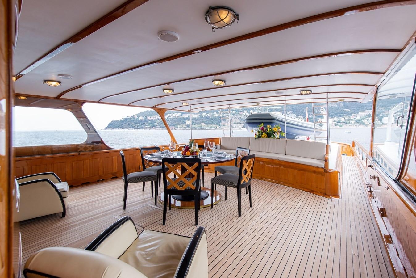 a deck with a table and chairs aboard SANS SOUCI Yacht for Sale