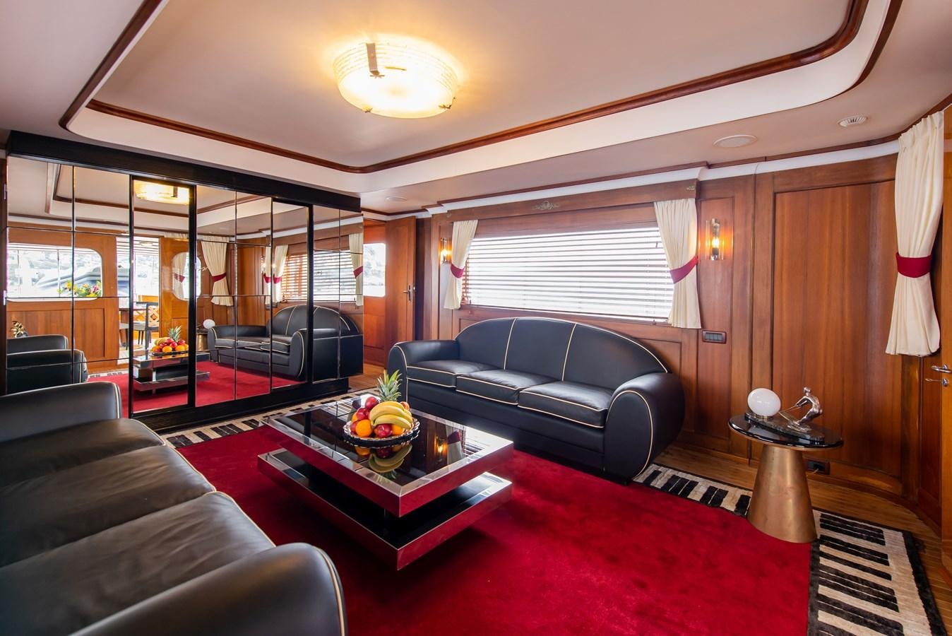 a living room with leather couches and a coffee table aboard SANS SOUCI Yacht for Sale