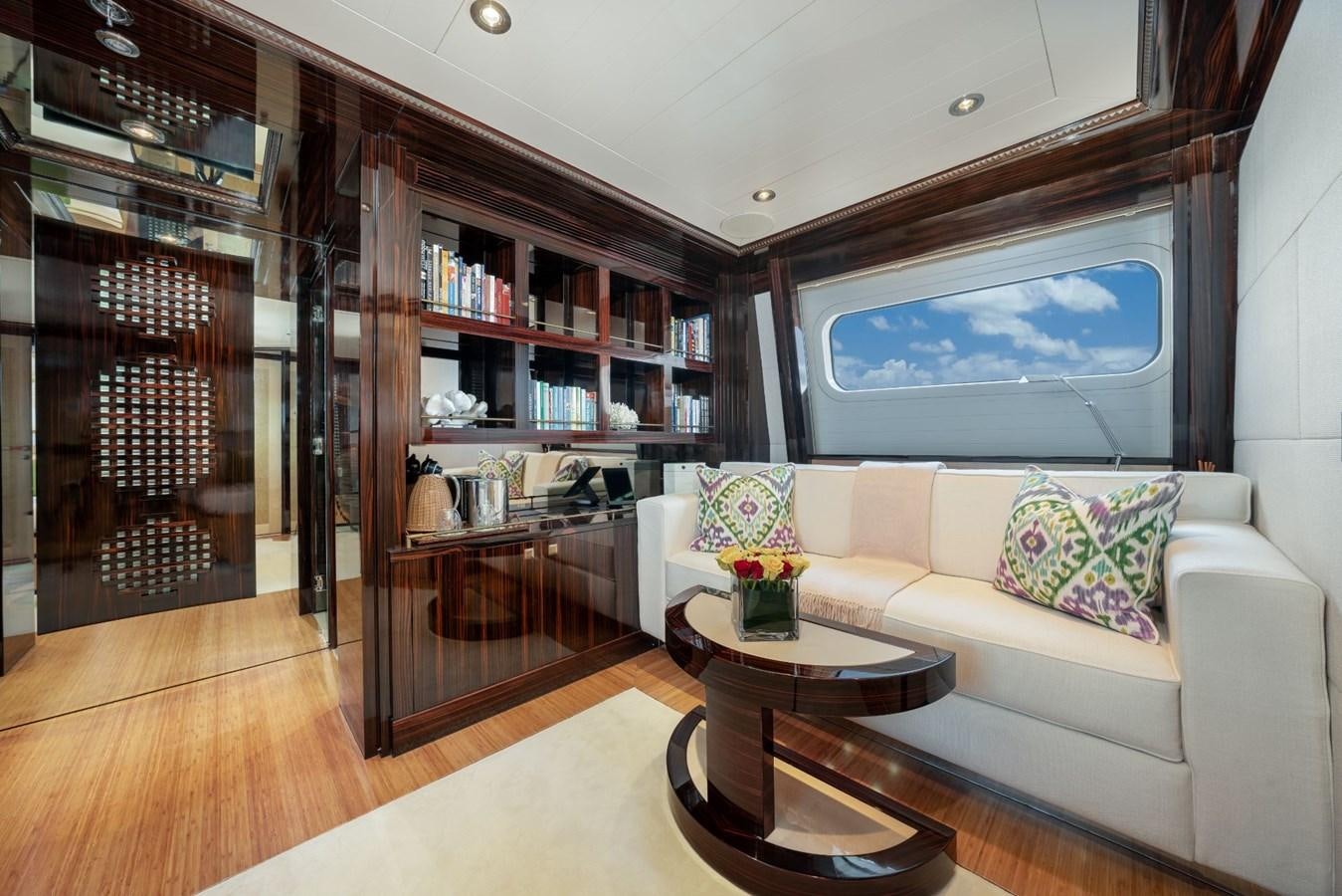a living room with a large book shelf and a couch aboard VESPER Yacht for Sale