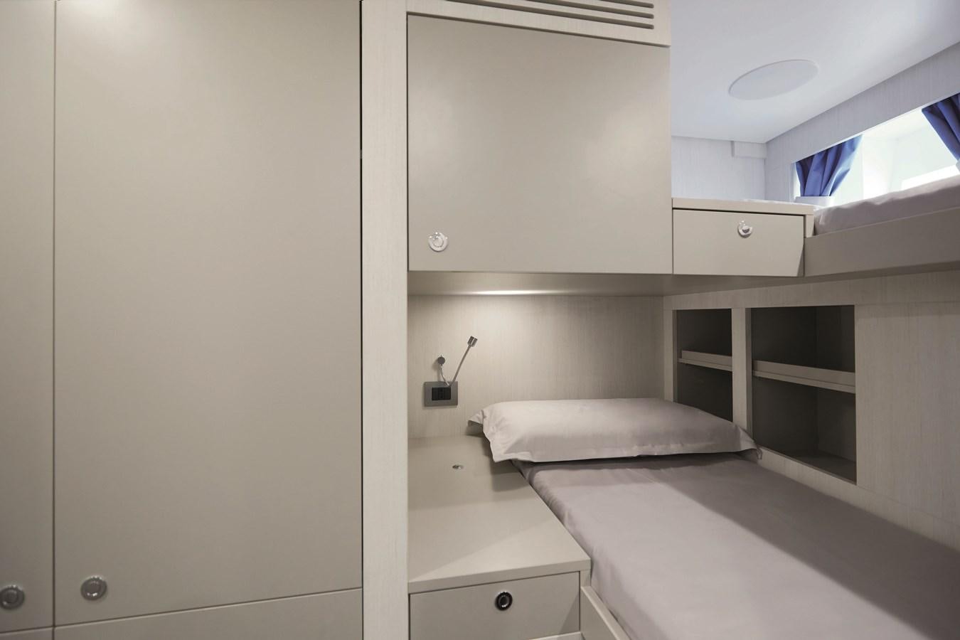 a room with a bed and cabinets aboard AL GASSAR 2022 Yacht for Sale