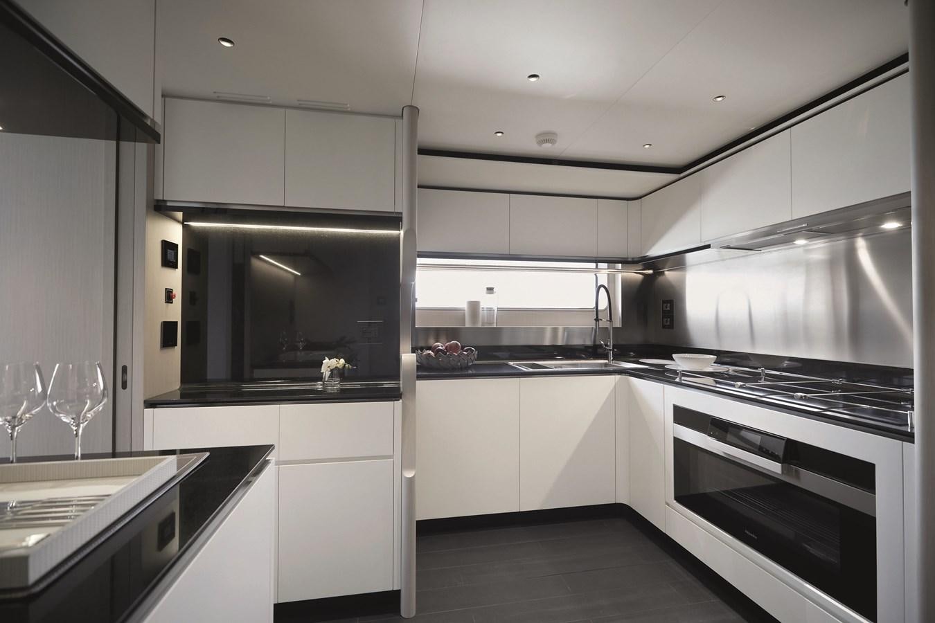 a kitchen with white cabinets aboard AL GASSAR 2022 Yacht for Sale