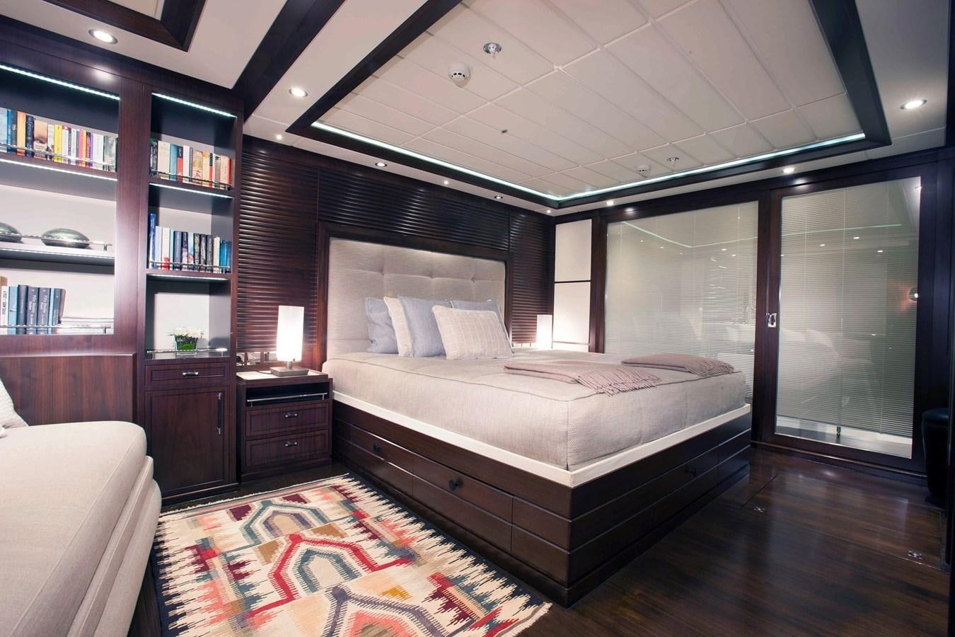 a bedroom with a bed and bookshelves aboard ICE LADY Yacht for Sale