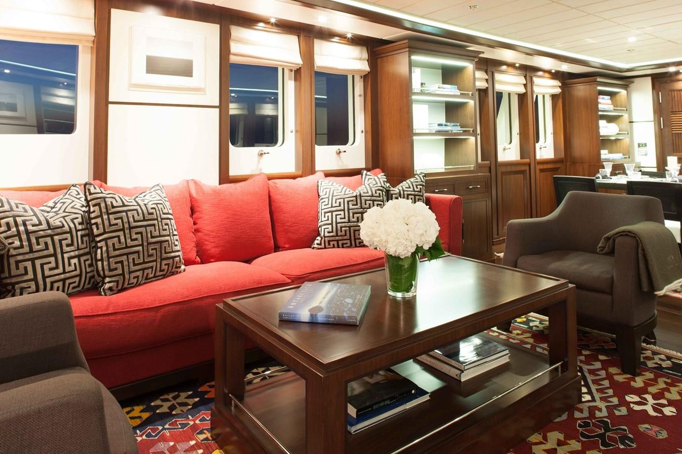 a living room with a table and couches aboard ICE LADY Yacht for Sale