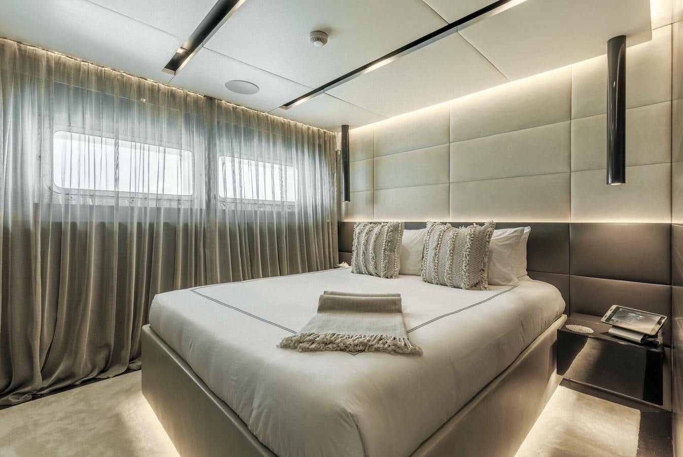 a bedroom with a bed and a window aboard SAFE HAVEN Yacht for Charter