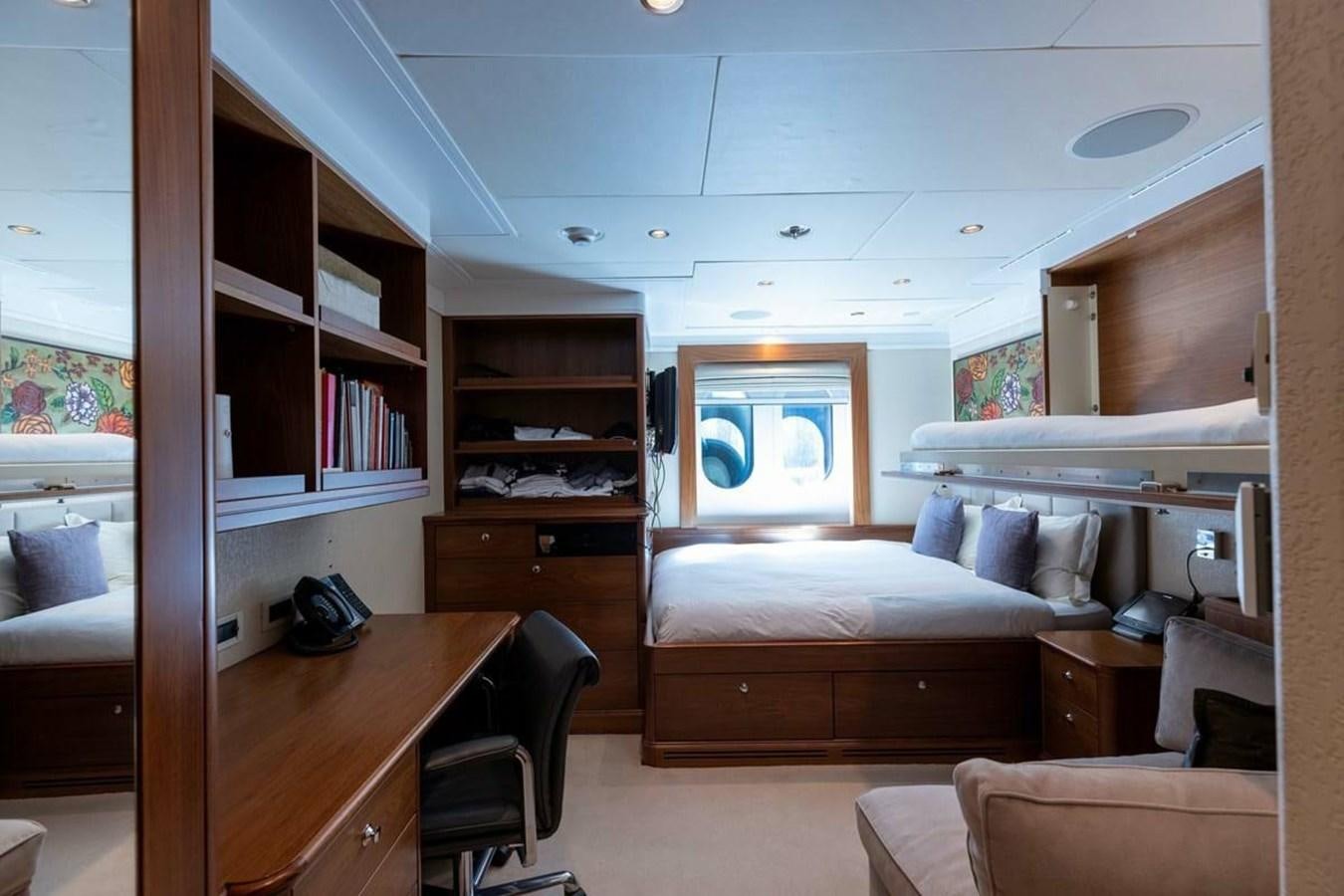 a bedroom with a bed and a desk aboard PURE Yacht for Sale