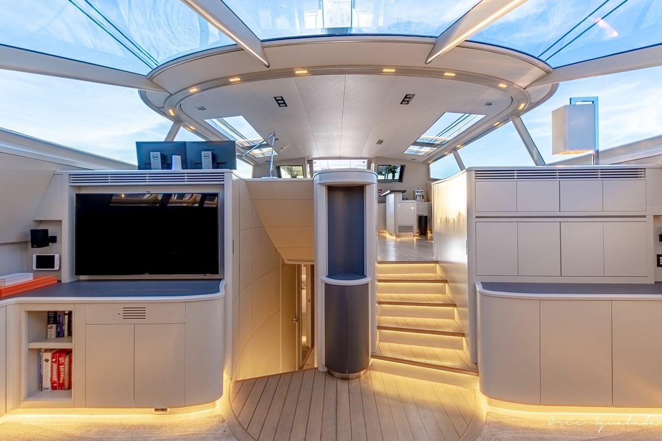 a room with a tv and a shelf with books aboard MY STAR Yacht for Sale