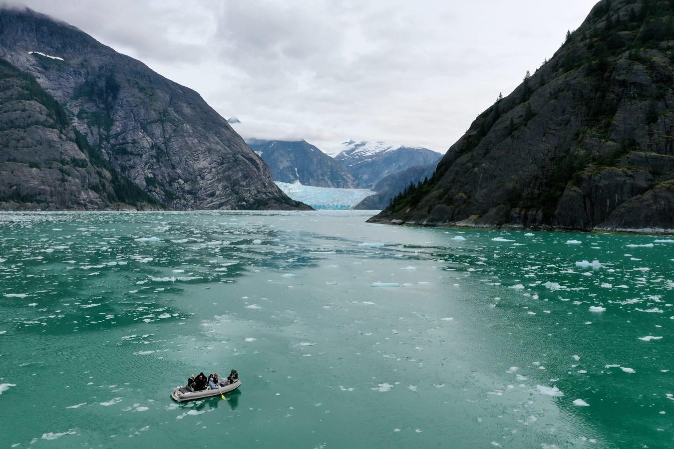 a couple people in a boat in Tracy Arm surrounded by mountains aboard MY STAR Yacht for Sale