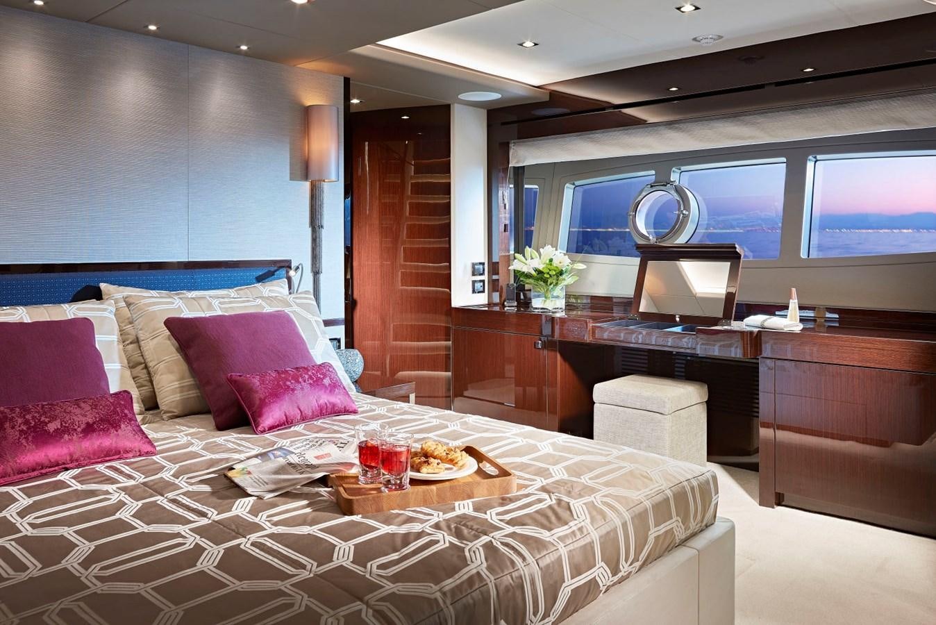 a large bed with a table and chairs in a room with a television aboard 95 YACHT Yacht for Sale