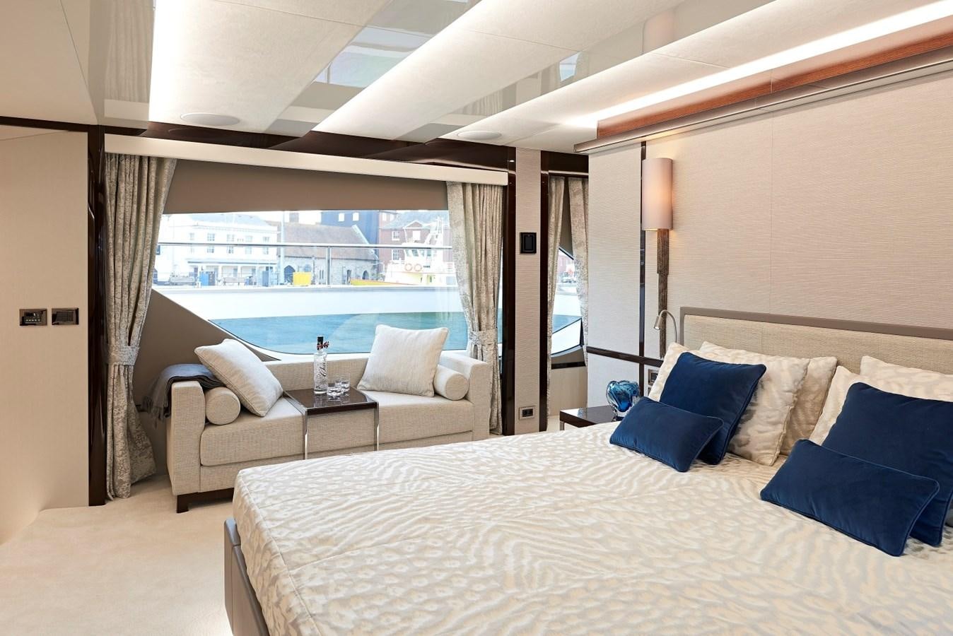 a bed with a white bed and blue pillows aboard 95 YACHT Yacht for Sale