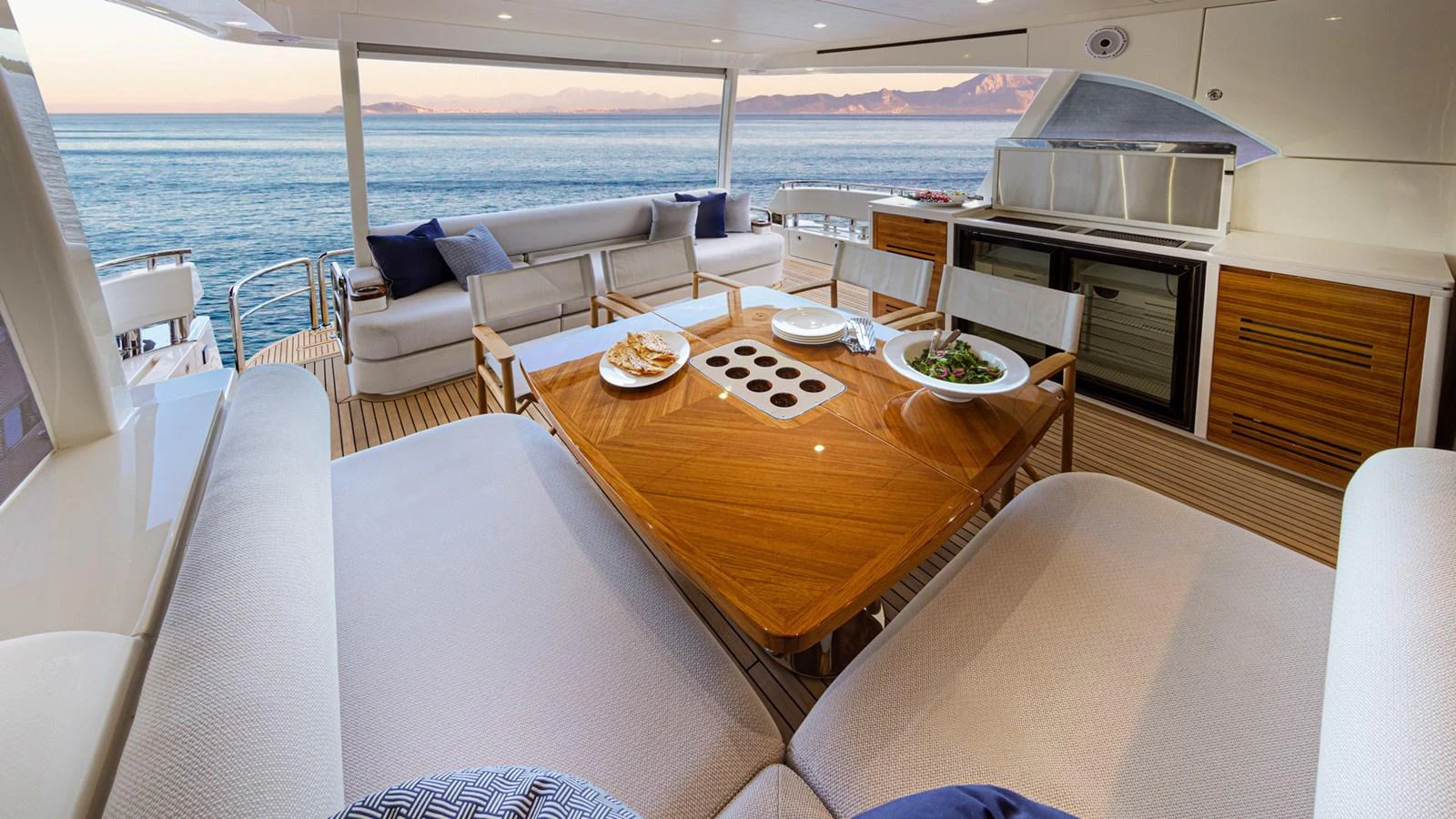 a table with a plate of food on it aboard 78 MOTOR YACHT ENCLOSED Yacht for Sale