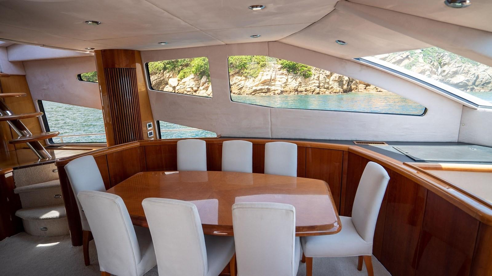 a room with a table and chairs aboard LUCKY BEAR Yacht for Sale