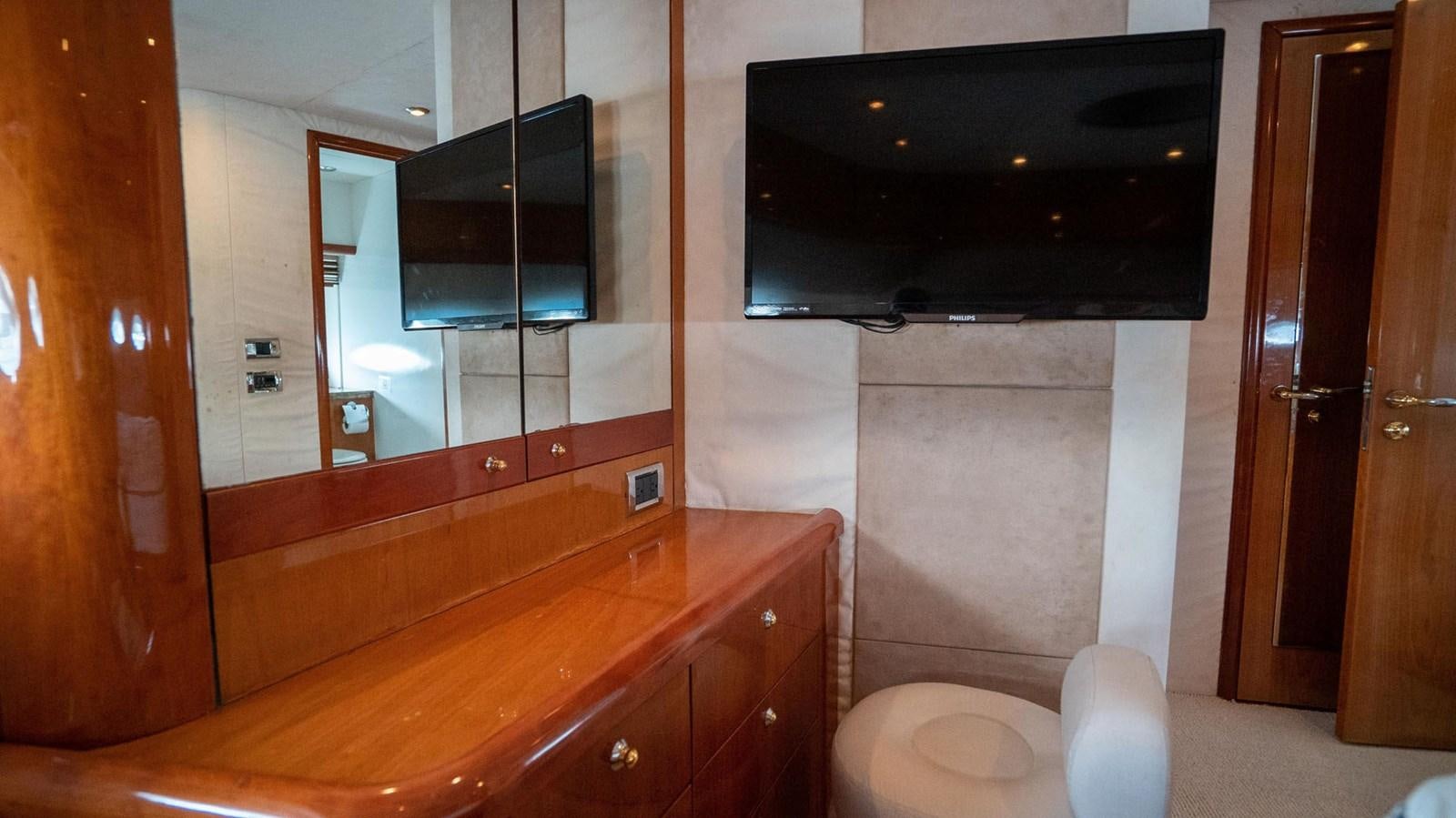 a bathroom with a television on the wall aboard LUCKY BEAR Yacht for Sale