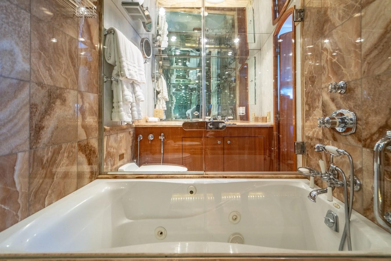 a bathroom with a bathtub and a mirror aboard DIAMOND LADY Yacht for Sale