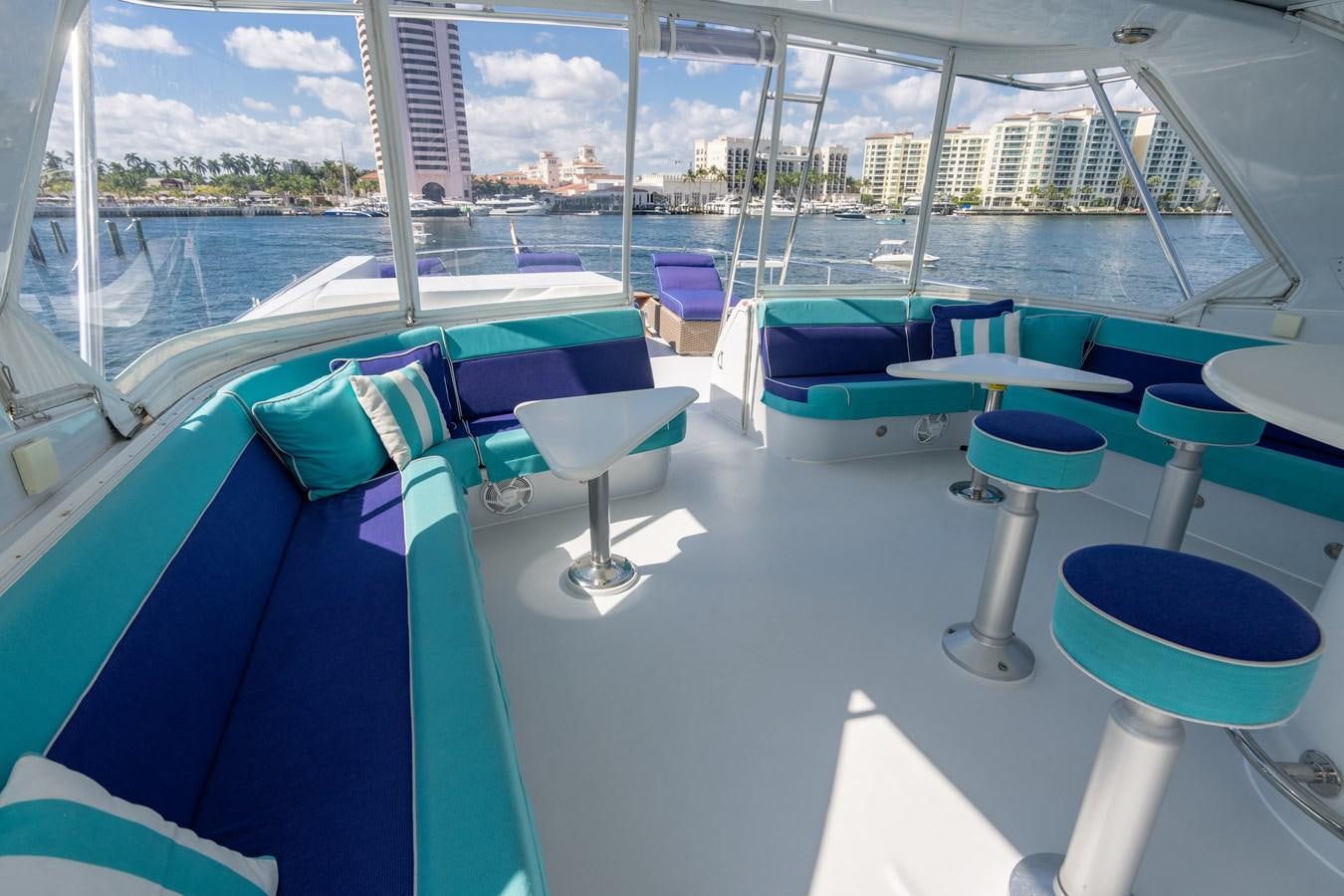 a table with chairs on it next to a window with a view of the water aboard DIAMOND LADY Yacht for Sale