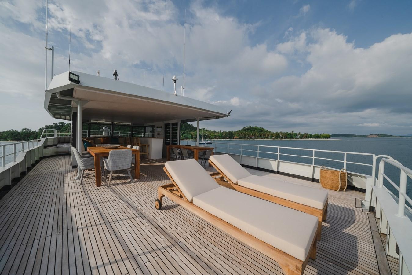 a deck with a table and chairs on it aboard SOUTHERN CROSS Yacht for Charter