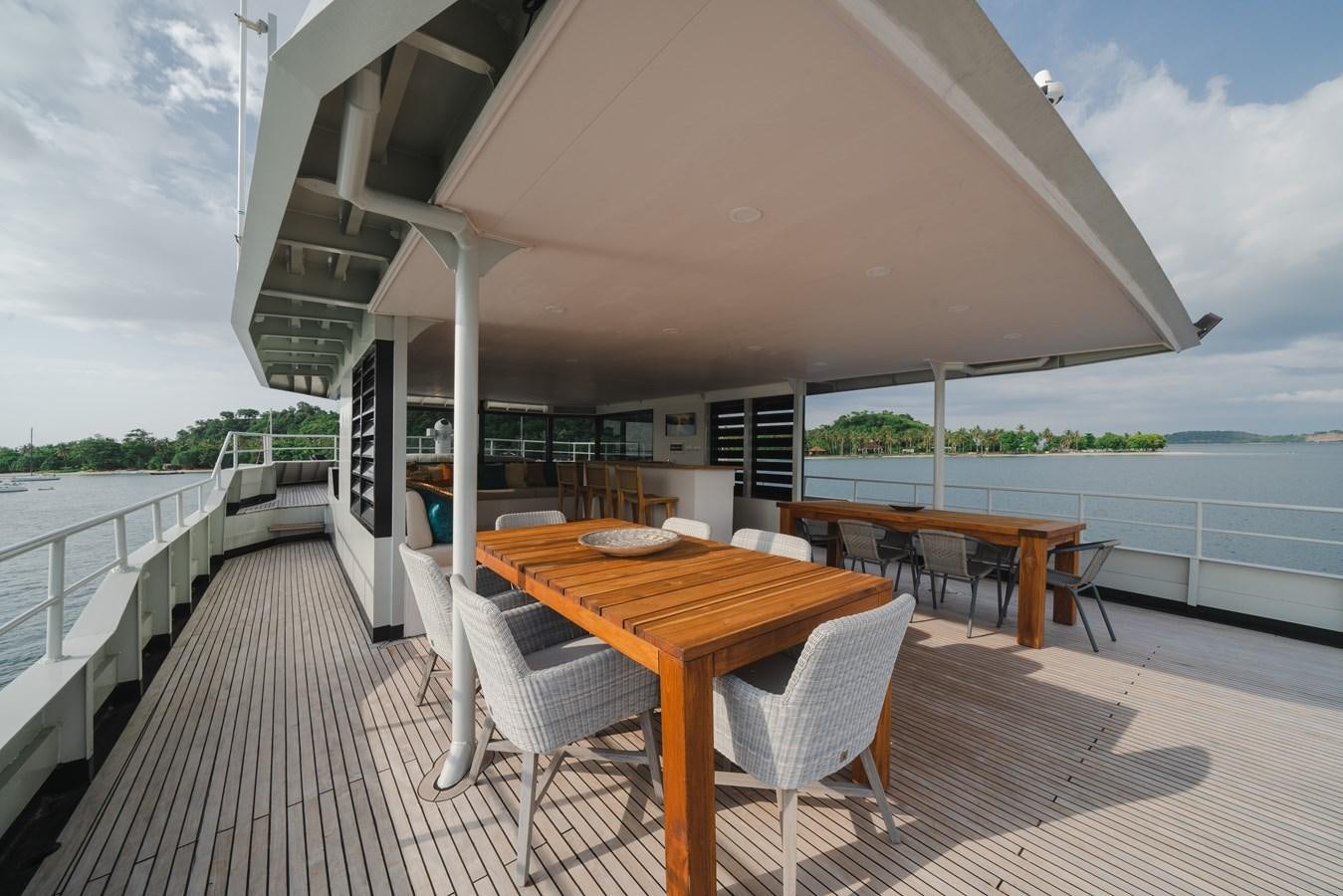 a covered patio with a table and chairs on a deck aboard SOUTHERN CROSS Yacht for Charter