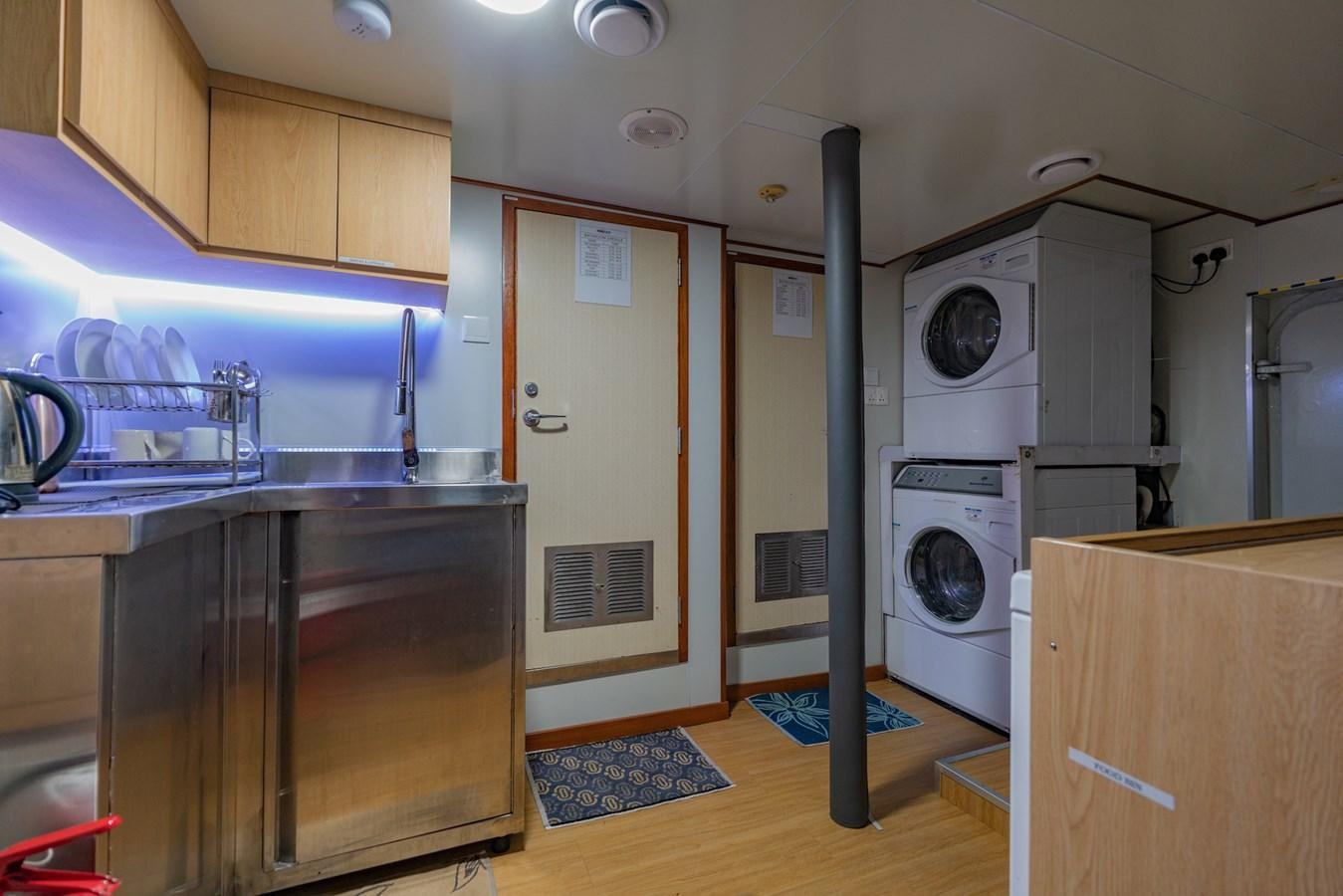 a kitchen with a washing machine and dryer aboard SOUTHERN CROSS Yacht for Charter