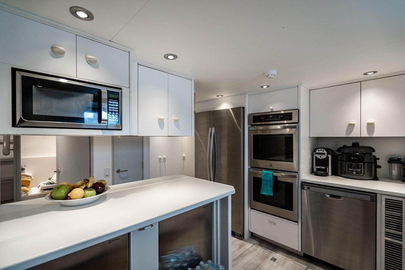 a kitchen with white cabinets aboard QUANTUM Yacht for Sale