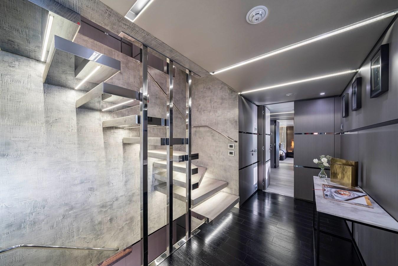 a room with a large wall of glass doors and a staircase aboard MAVERICK Yacht for Sale