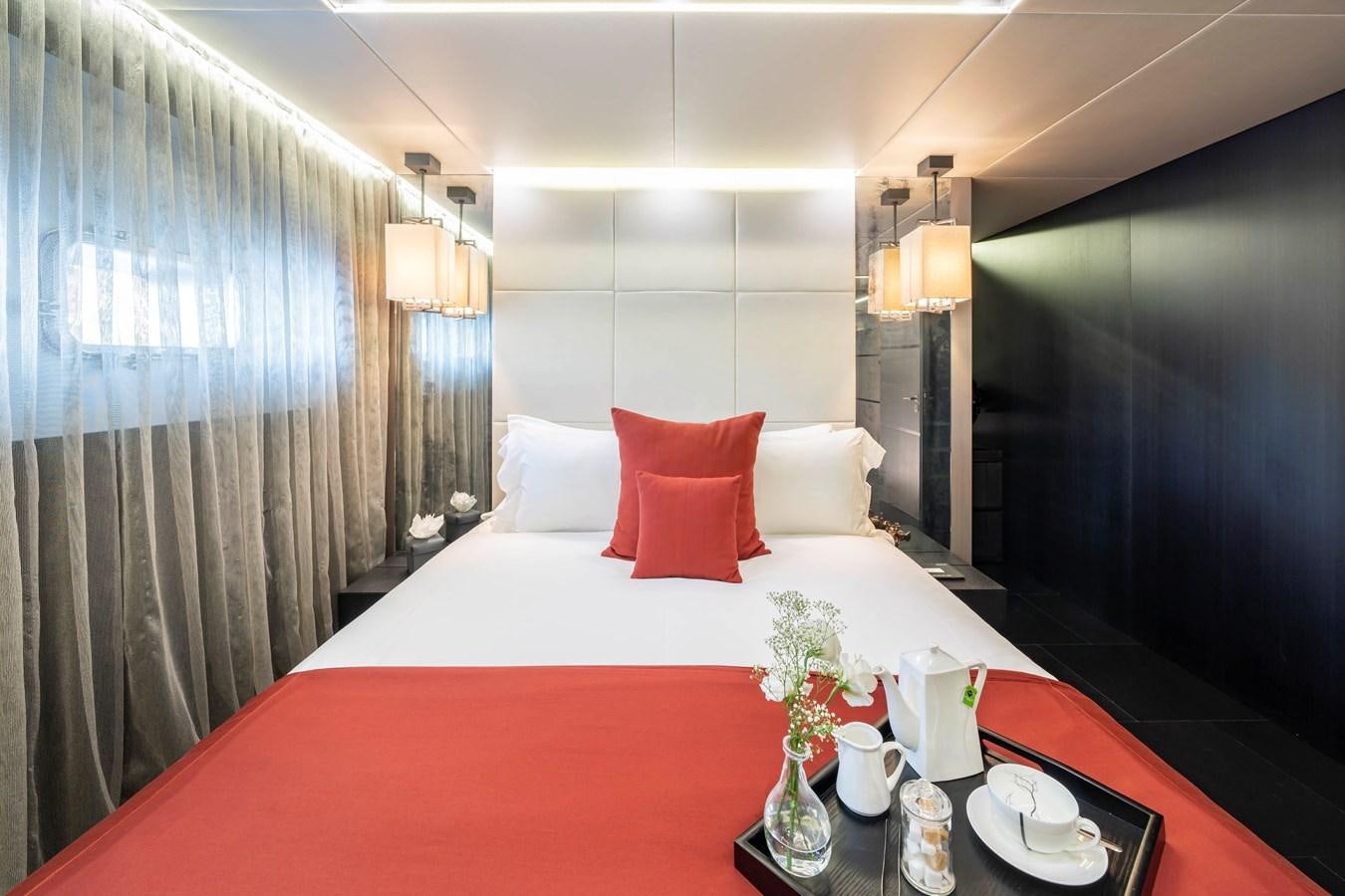 a bed with a red and white bed spread aboard MAVERICK Yacht for Sale