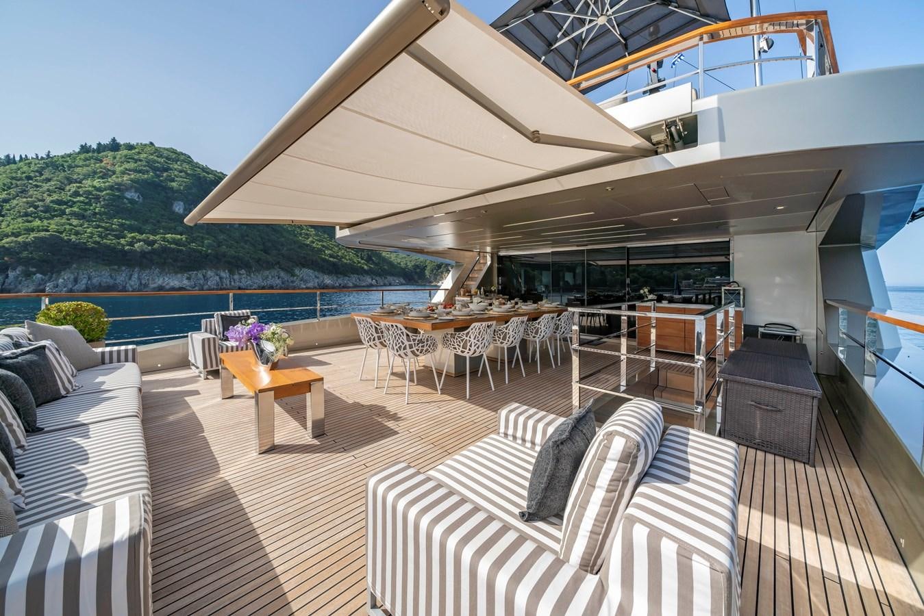 a deck with a table and chairs aboard MAVERICK Yacht for Sale