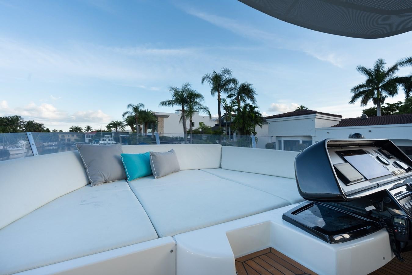 a white couch and a white car on a patio with trees and a blue sky aboard 75' RIVA 2012 Yacht for Sale