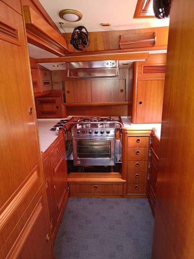 a kitchen with wooden cabinets aboard PLUM Yacht for Sale