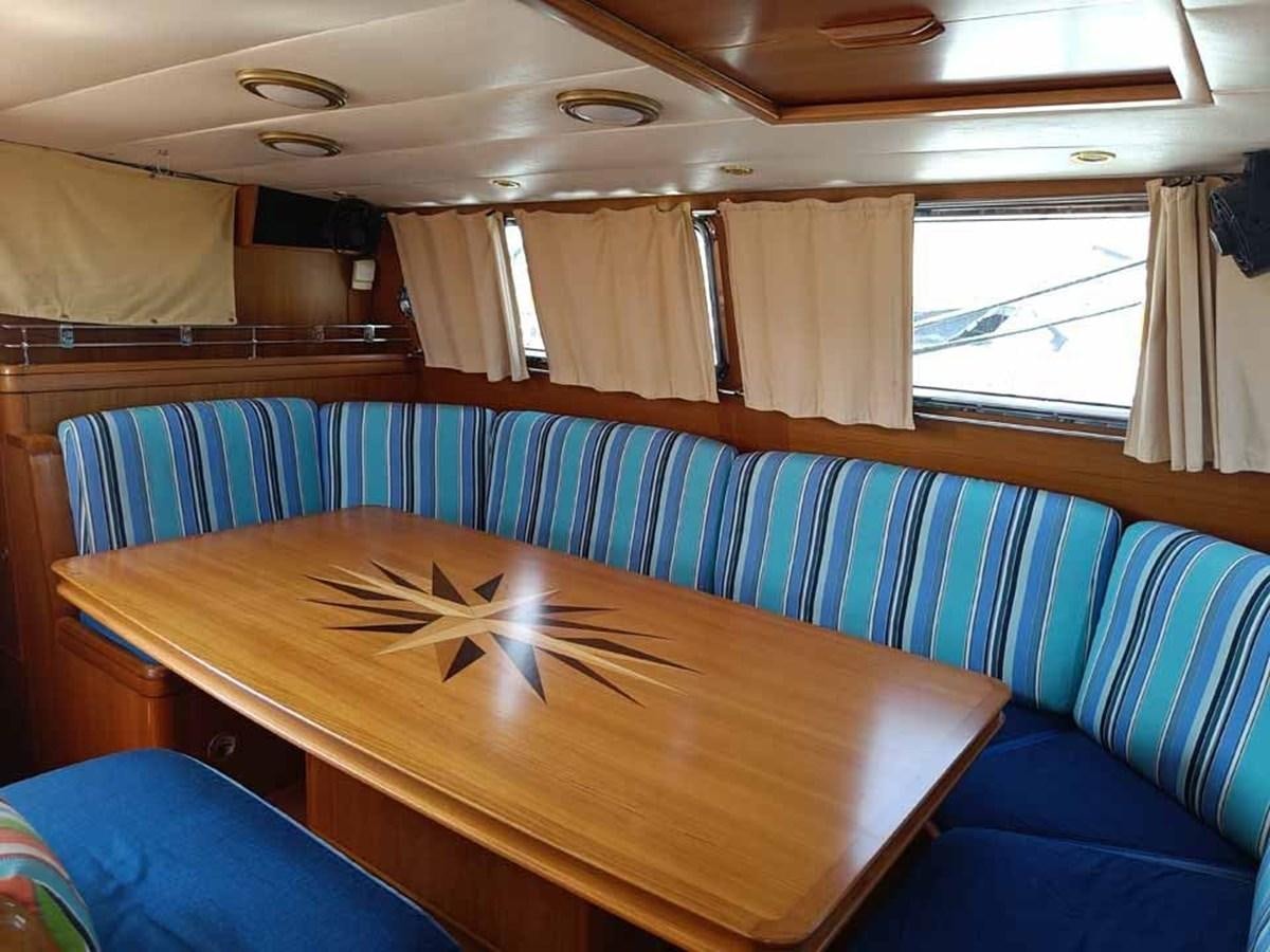 a boat with a table and chairs aboard PLUM Yacht for Sale
