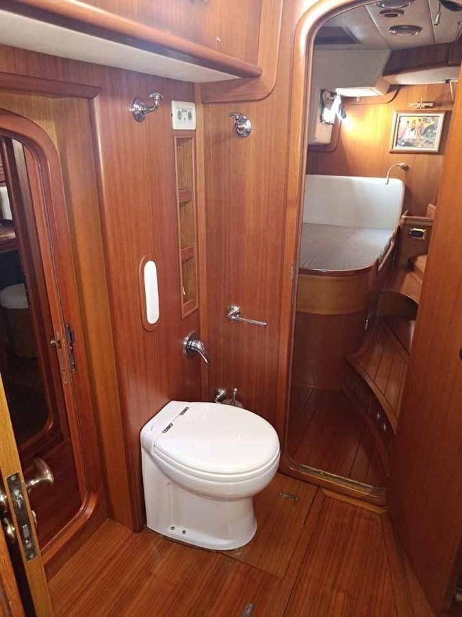 a bathroom with a toilet and bathtub aboard PLUM Yacht for Sale