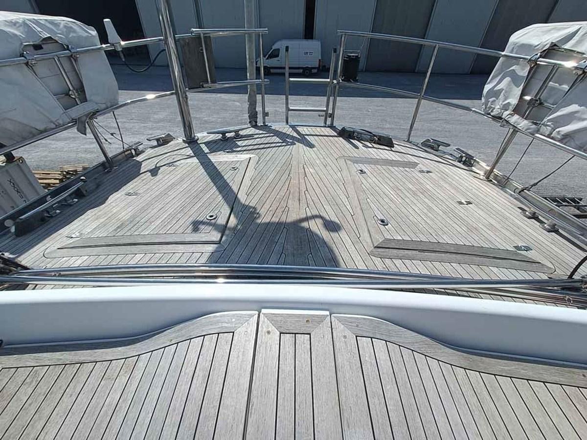 a deck with a railing and a railing with a railing and a building in the background aboard PLUM Yacht for Sale