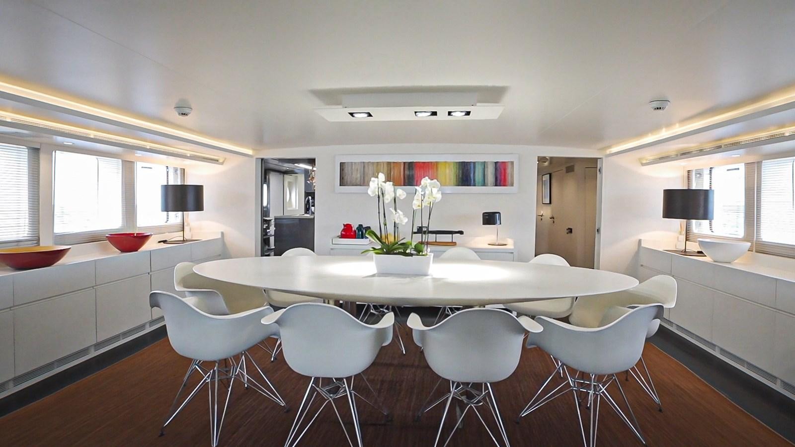 a kitchen with white chairs aboard BERZINC Yacht for Charter
