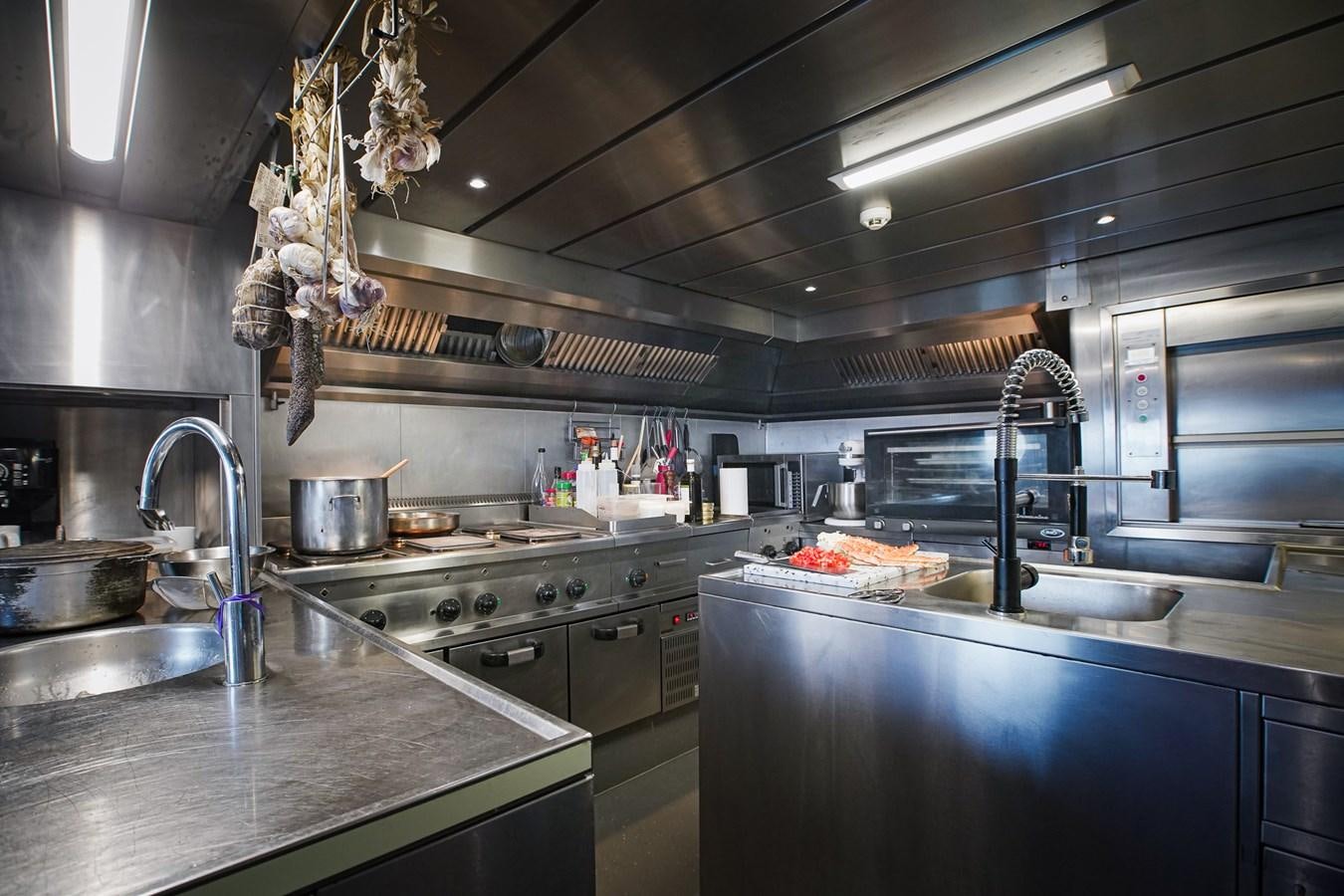 a kitchen with a chandelier and a sink aboard BERZINC Yacht for Charter