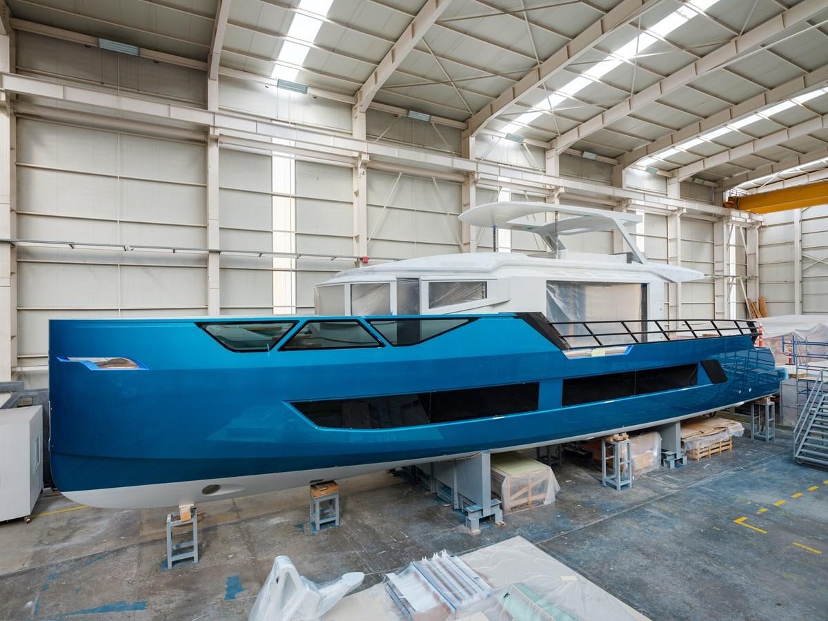 a large blue boat in a warehouse aboard EDGE - XSR 85 #NB201 Yacht for Sale