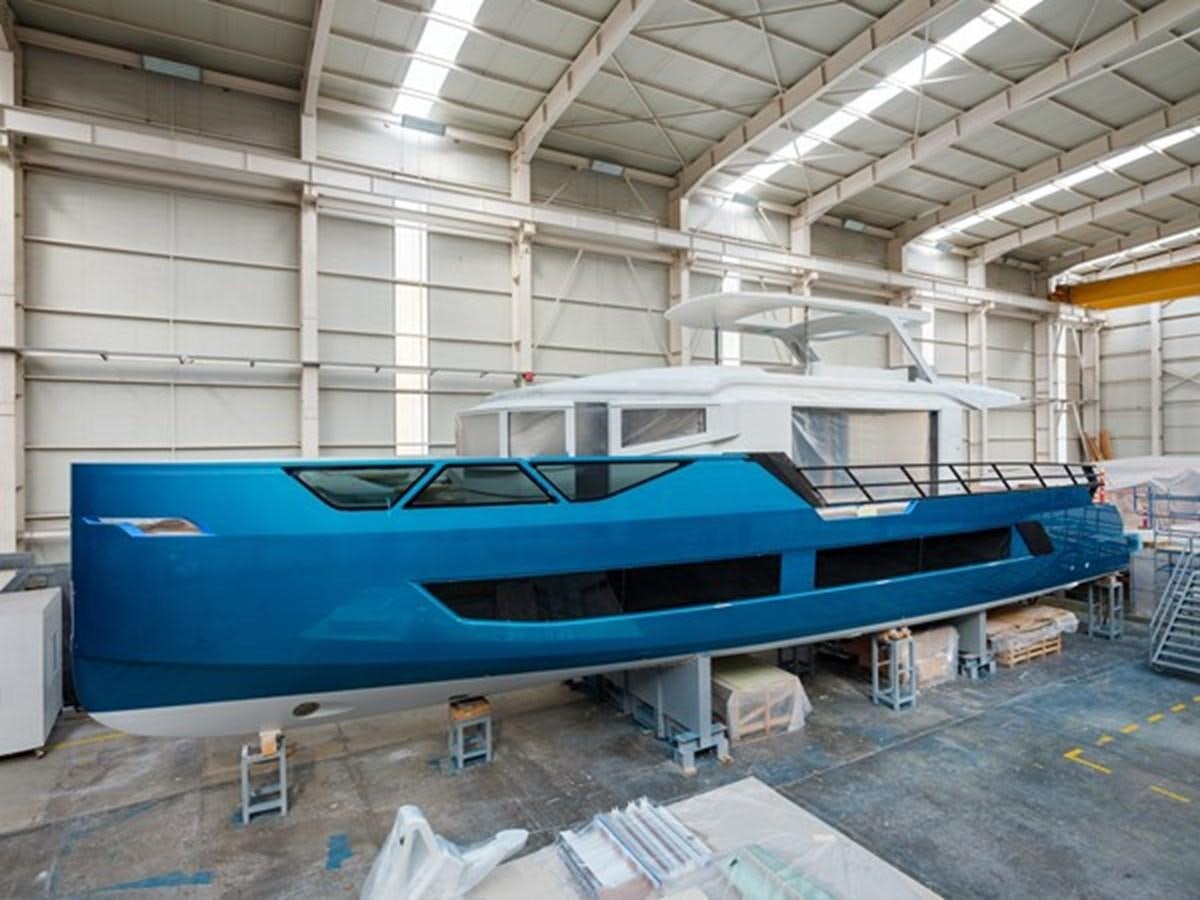 a large blue boat in a warehouse aboard EDGE - XSR 85 #NB201 Yacht for Sale