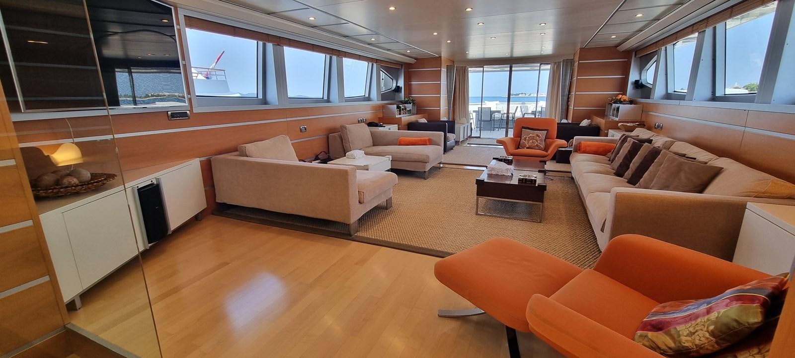 a living room with orange couches aboard CHOO CHOO Yacht for Sale