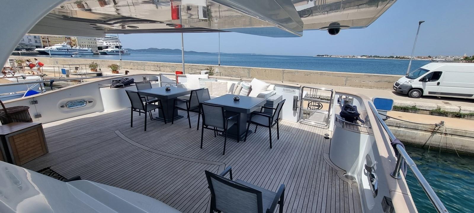a deck with a table and chairs on it aboard CHOO CHOO Yacht for Sale