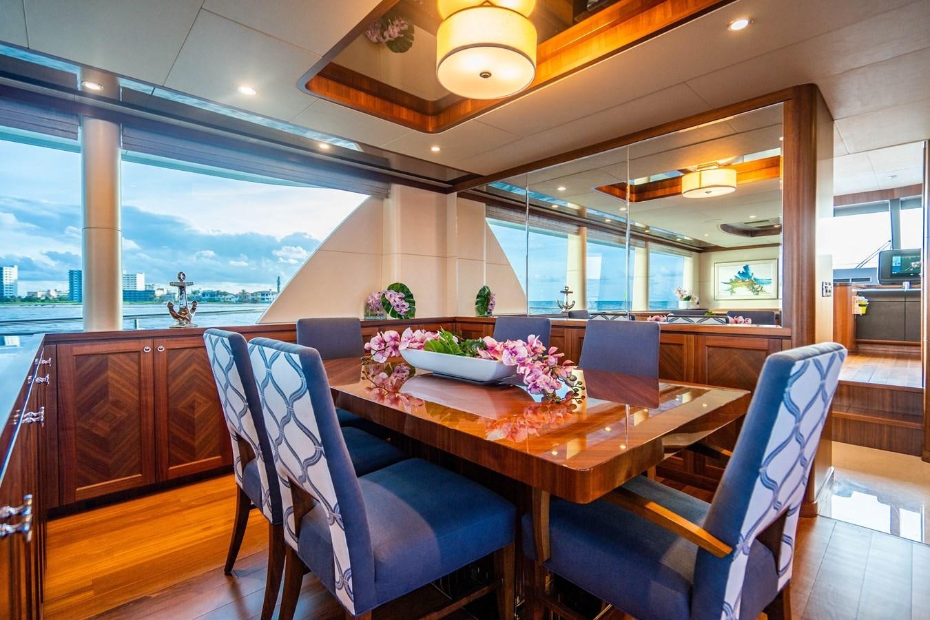 a dining table with chairs and a view of the ocean aboard PICO Yacht for Sale