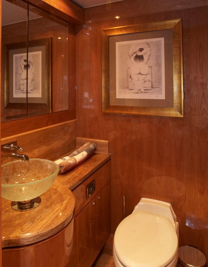 a bathroom with a painting on the wall aboard LADY C II Yacht for Sale