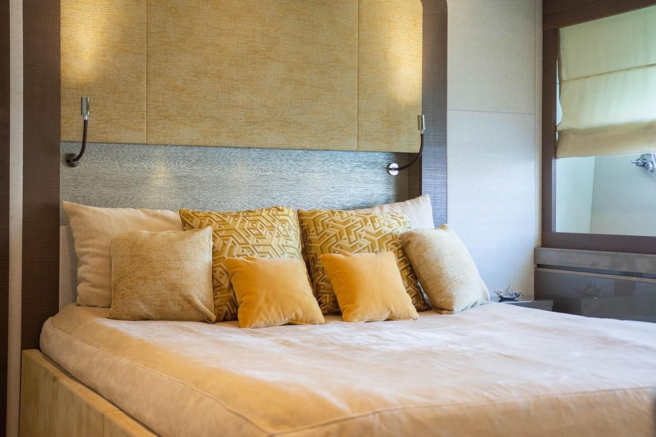 a bed with yellow pillows aboard GV Yacht for Sale