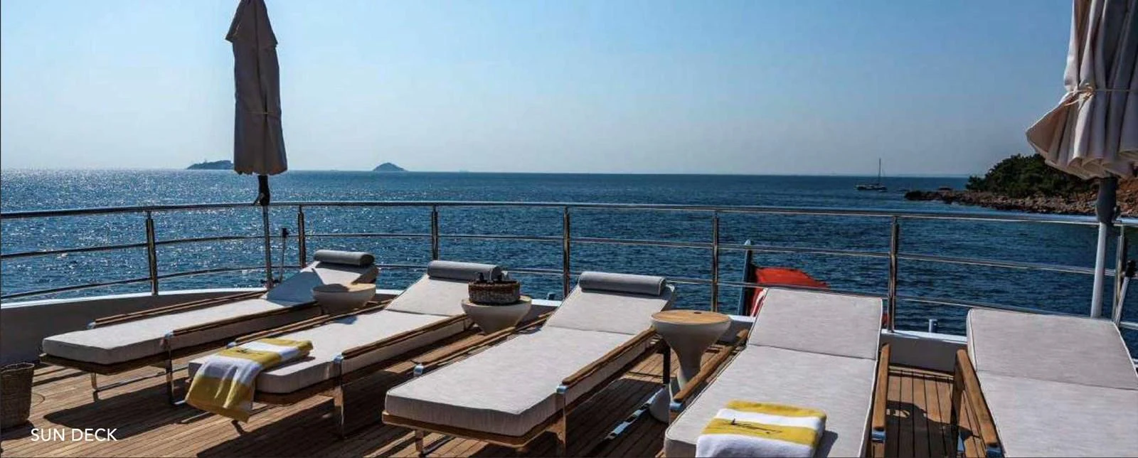 a deck with chairs and tables on it by the water aboard MOONRAKER Yacht for Sale