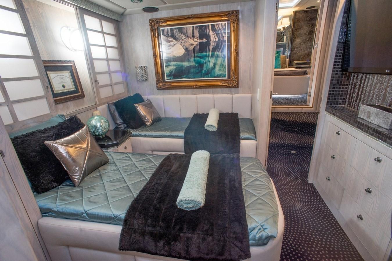 a bedroom with a bed and a chair aboard JACO Yacht for Sale