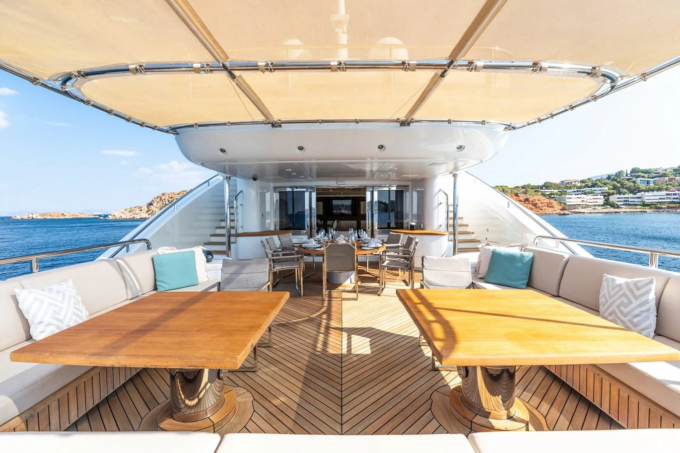 a deck with a table and chairs on it aboard ROLA Yacht for Sale