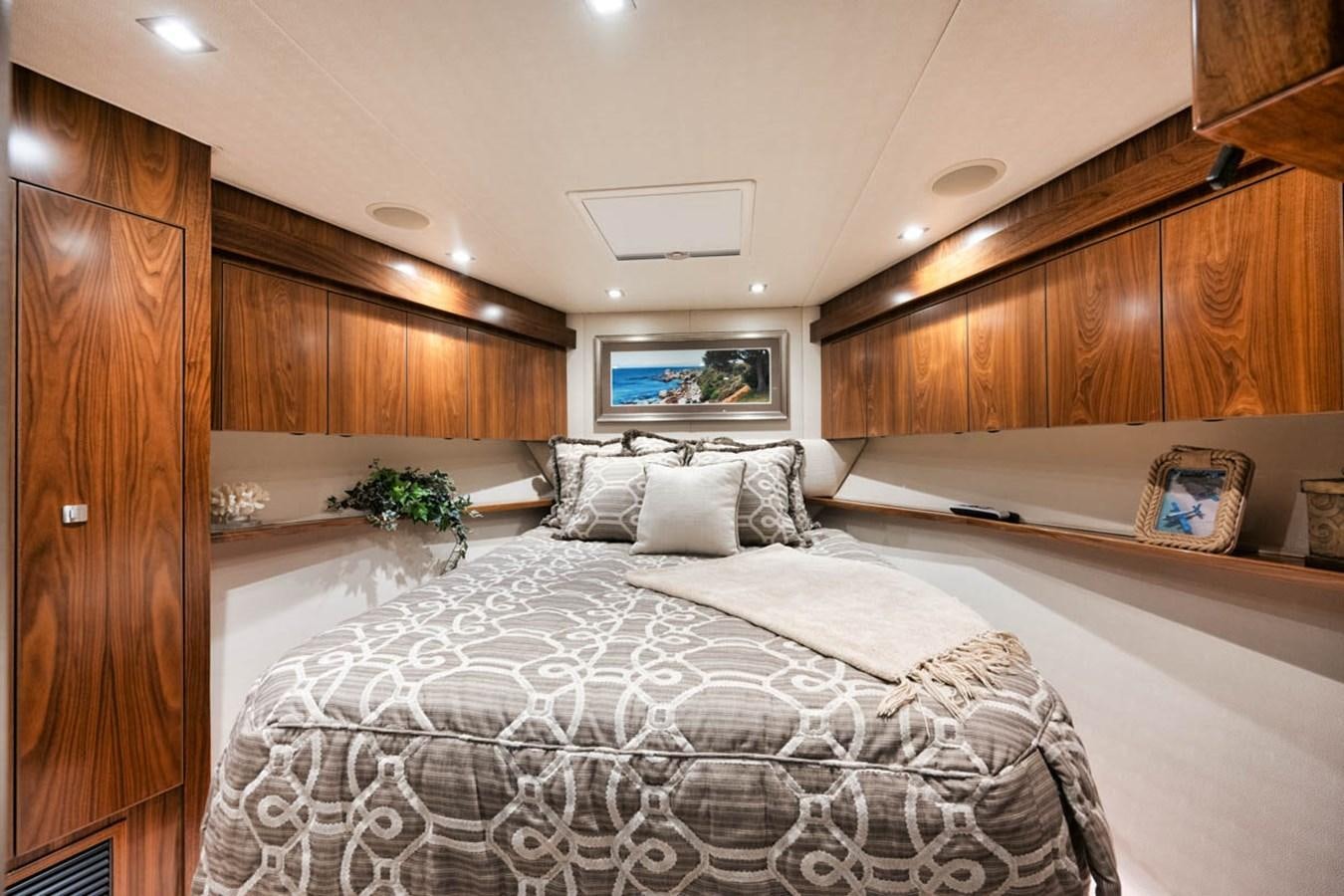 a bedroom with a bed and a wood cabinet aboard MVP Yacht for Sale