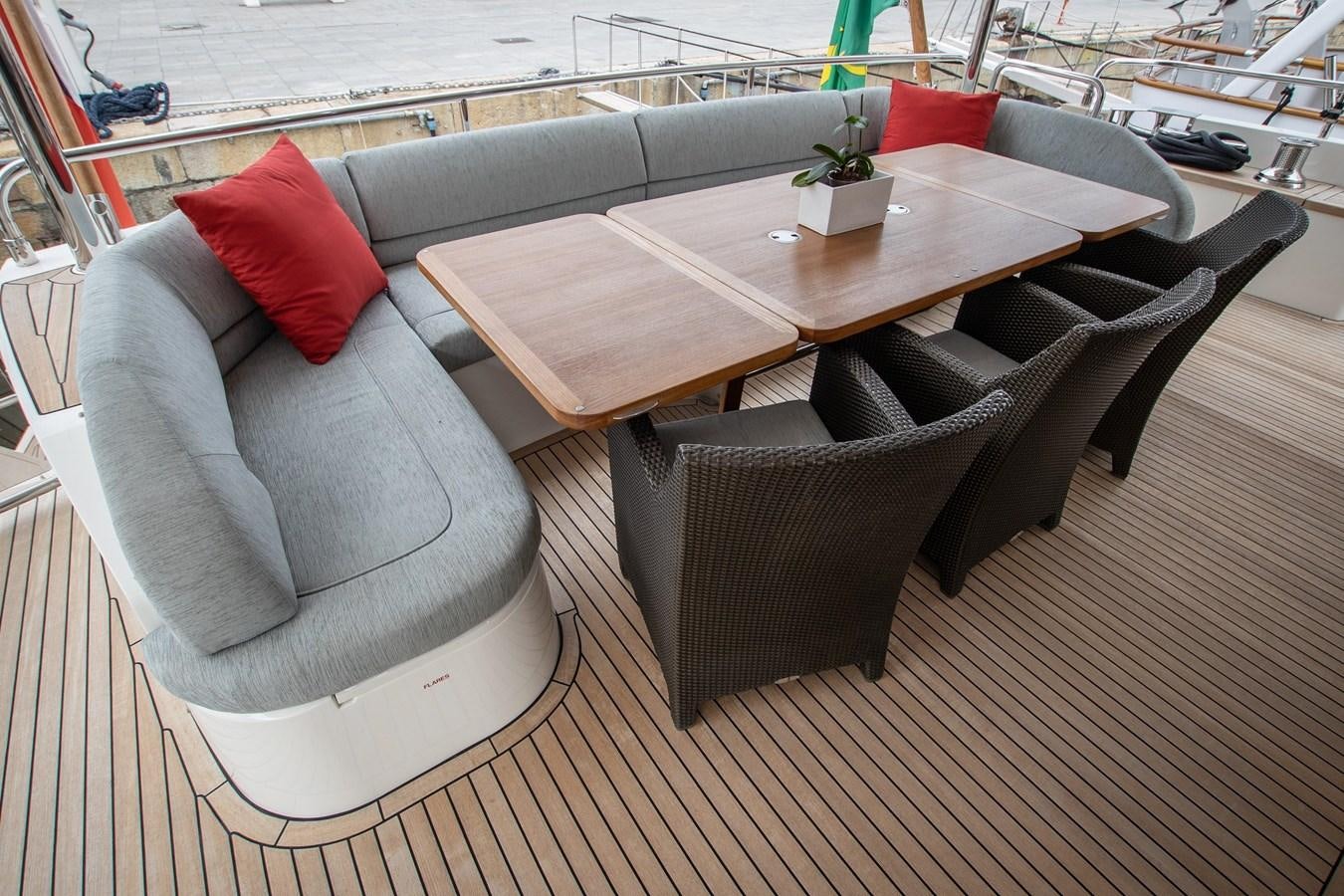 a couch and a table on a deck aboard ROSSO Yacht for Sale