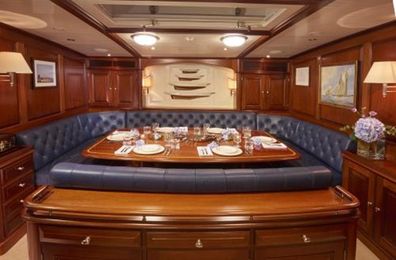 a large wooden table with plates and glasses on it aboard BORKUMRIFF IV Yacht for Sale