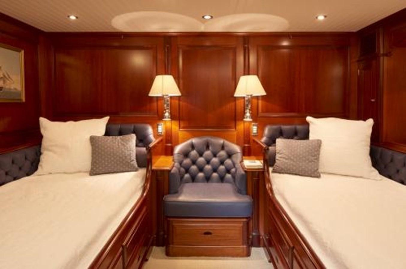 a bed with a blue chair aboard BORKUMRIFF IV Yacht for Sale