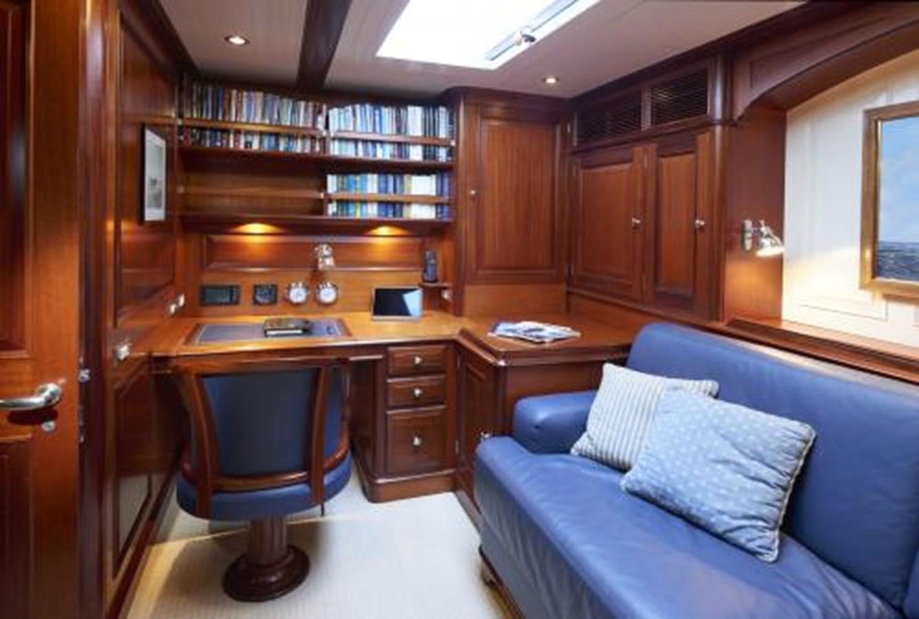 a living room with a couch and a bookcase aboard BORKUMRIFF IV Yacht for Sale