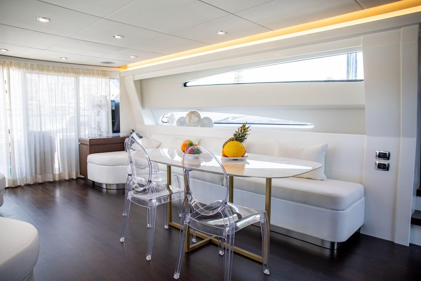 a white living room with a white couch and a table aboard VEVEKOS Yacht for Sale